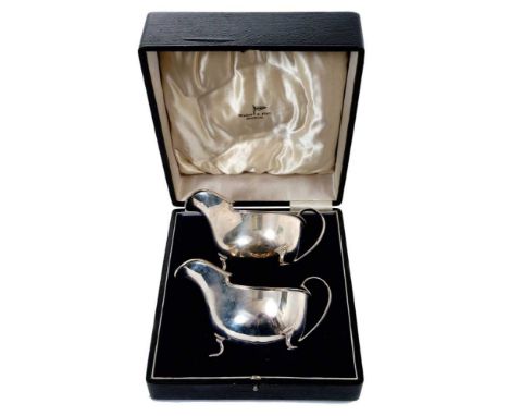 Pair of 1930s Art Deco style silver sauce boats of helmet form, with engraved initials, on three paw feet, in a fitted case (