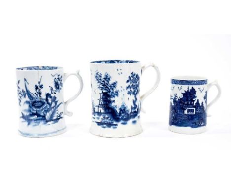 Three Lowestoft cylindrical mugs, including one with a spreading foot and scrolled handle, boldly painted in blue with flower