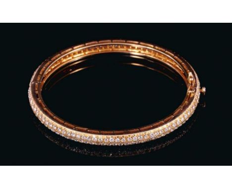 Diamond hinged bangle with approximately 174 pavé set brilliant cut diamonds in yellow gold setting. Estimated total diamond 