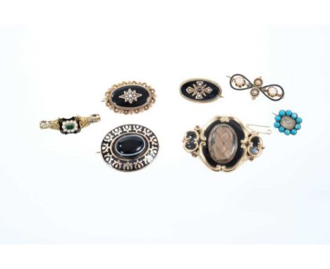 Seven Regency and Victorian mourning brooches to include a Regency gold enamel and emerald ring converted to a brooch, dated 