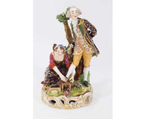 Derby group of the 'shoe black', c.1820, the figures on a grassy mound on top of a round gilt scrollwork base, inscribed mark