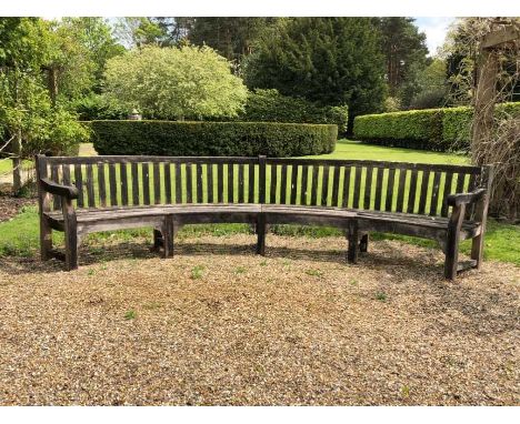 Large teak garden bench of semi-circular form, approximately 350cm wideCondition report: Solid and rather weathered , some ro