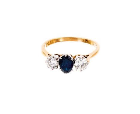 Sapphire and diamond three stone ring with an oval mixed cut blue sapphire flanked by two brilliant cut diamonds in platinum 