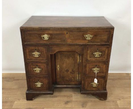 George I walnut crossbanded desk, with caddy moulded top and seven drawers and concealed frieze drawer about the cupboard kne