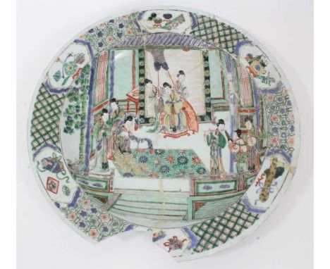 Chinese Kangxi period famille verte dish, painted with an interior scene with figures and attendants, the border with panels 