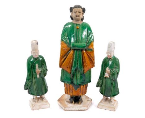 Three Chinese Sancai-glazed pottery figures, probably Ming dynasty, including a pair of smaller male attendants, 22.5cm high,