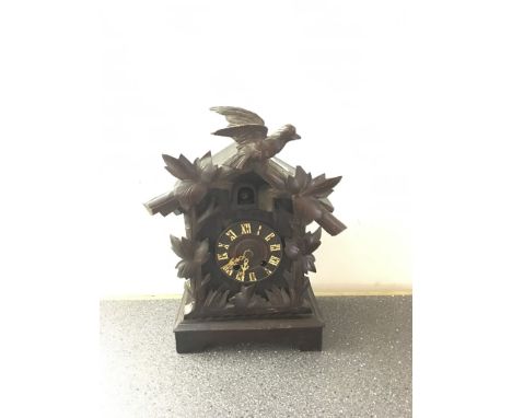 A carved freestanding cuckoo clock