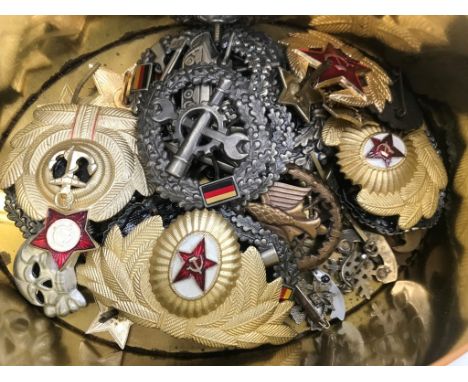 A quantity of German and Russian post-war breast awards, cap badges; together with USAAF B-8 flying goggles