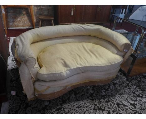 An early 20th century kidney shaped sofa (in need of re-upholstering)