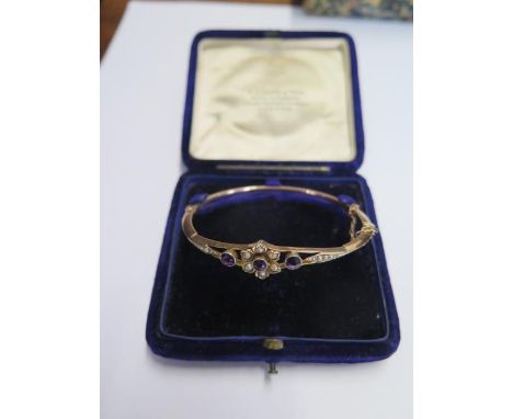A 9ct yellow gold amethyst and pearl hinged bangle - 6.5cm x 5.5cm external - approx weight 6.6 grams - generally good condit