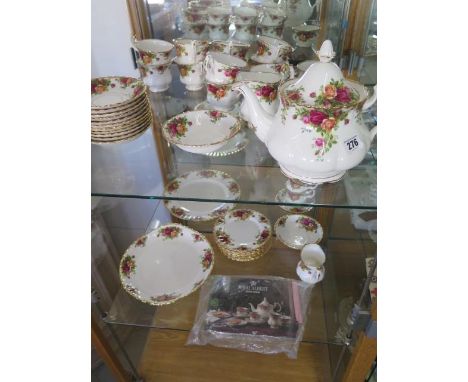 A Royal Albert Country Rose tea set - tea pot, milk jug, sugar basin, a cake plate, nine cups, saucers, tea plates, a dinner 