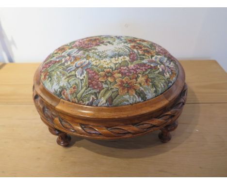 A Victorian walnut footstool with tapestry top in polished condition - Diameter 32cm 