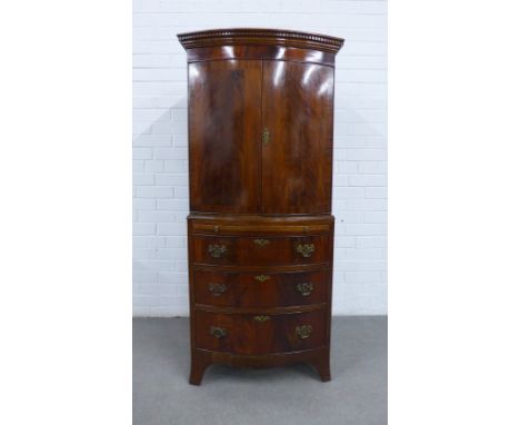 Mahogany cabinet with a dentil frieze over a pair of cupboard doors with a shelved interior above a pull out slide and three 