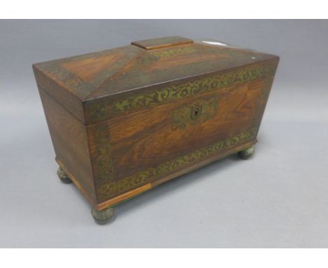 19th century rosewood and brass inlaid tea caddy of sarcophagus form, the hinged lid opening to reveal two lidded compartment