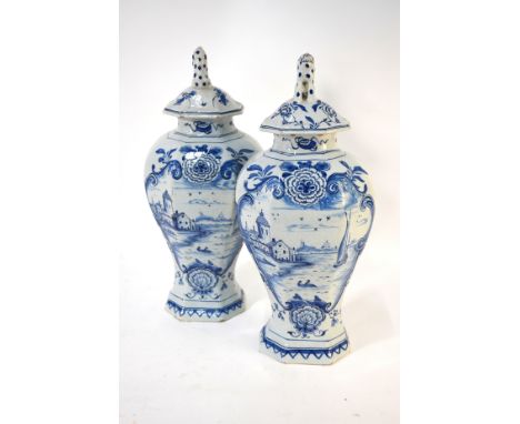 A pair of 19th century Dutch Delft blue and white vases of octagonal form, painted with a Dutch water scene within a Chinoise