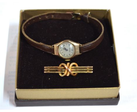 A contemporary yellow metal brooch formed of three parallel bars with knot motif around, stamped 9ct, approx 2.3g to/w lady's