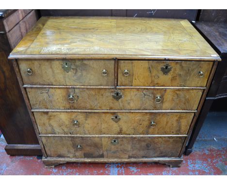 A late 17th century walnut chest of two short over three long graduated drawers, with brass ring pulls, raised on short brack