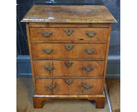 A George II style antique cross-banded walnut chest of four graduated drawers beneath a brush slide, raised on shaped bracket