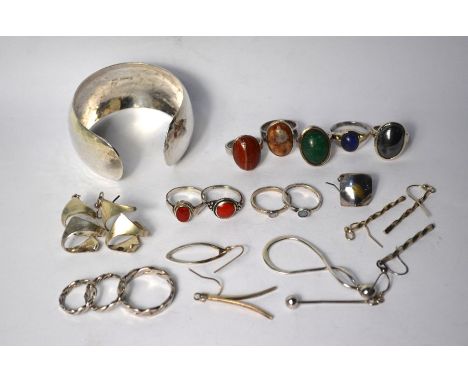 A collection of contemporary silver and white metal jewellery items including a hammered open bangle, various earrings and ri