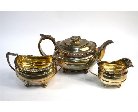 A heavy quality silver three-piece tea service in the Regency manner with floral-chased handles, gadrooned rims and ball feet