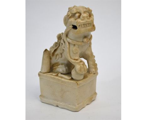 A Blanc-de-Chine figure of a male Buddhistic Lion with his right paw on a ball; probably a joss-stick holder, 13.5 cm high, Q