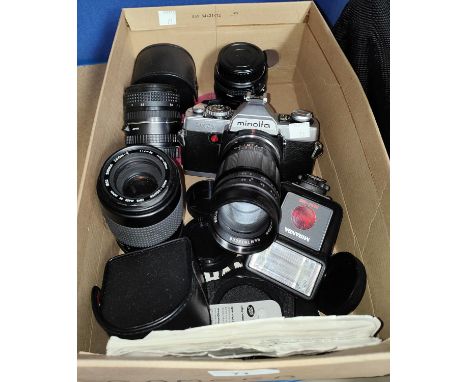 A vintage Minolta XG1 with soldier telephoto lense; three other lenses and accessories; a digital Canon camera F051000F. 