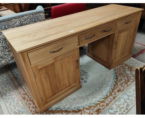 A large modern light oak desk, two large cupboards to each pillar and three frieze drawers, length 170cm, depth 55 x height 8