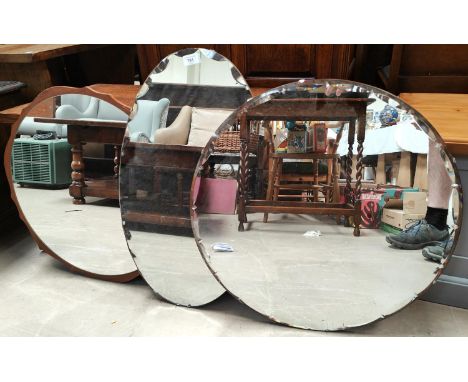 Three vintage mirrors one circular with teak surround, one oval and one circular both with bevels edges around the sides