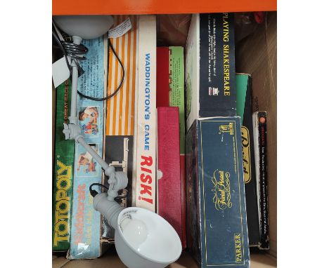 A collection of vintage board games and a modern lamp 