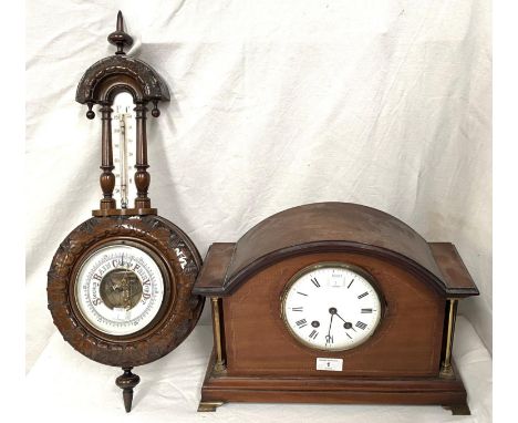 An Edwardian aneroid barometer and thermometer in carved walnut case; an Edwardian striking mantel clock in mahogany arch top