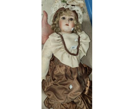 A late 19th/early 20th century bisque head girl doll with glass eyes, composition body and jointed limbs, real hair wig, in b