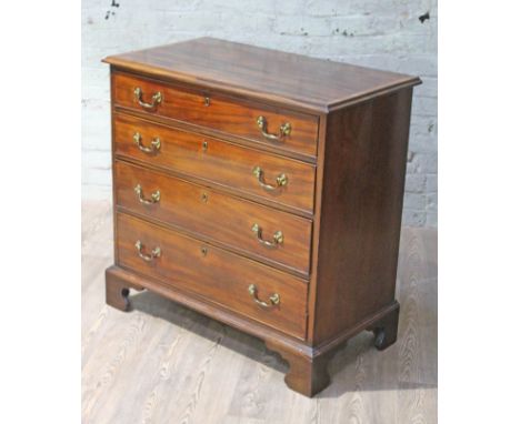 A Georgian mahogany chest of drawers with crossbanded and moulded top, swan neck gilt brass handles and bracket feet, width 9