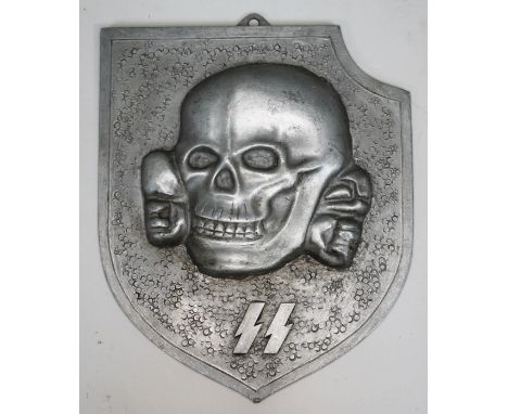 An SS skull and cross bones cast aluminium plaque, length 18cm.  