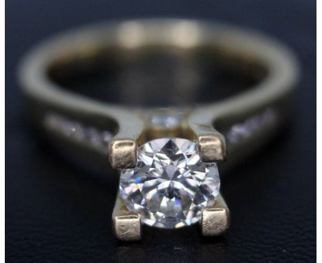 A diamond solitaire ring, the central modern round brilliant cut stone approx. 0.90 carats, set above diamond shoulders in fo