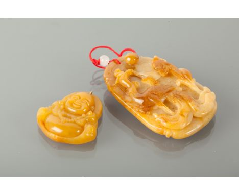 TWO CARVED PENDANTS both possibly jade, both with beige tones, one carved to depict a seated buddha 34mm high, the other carv