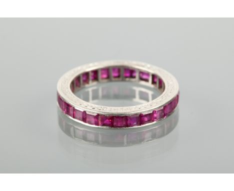 ART DECO RUBY FULL ETERNITY RING with channel set rectangular rubies, engraved to the edge with a knotted motif, marked PLAT 