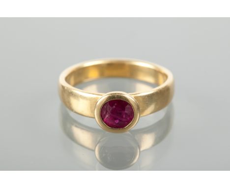 LATE TWENTIETH CENTURY RUBY RING set with a single oval ruby approximately 6mm across, in a broad tapered band approximately 