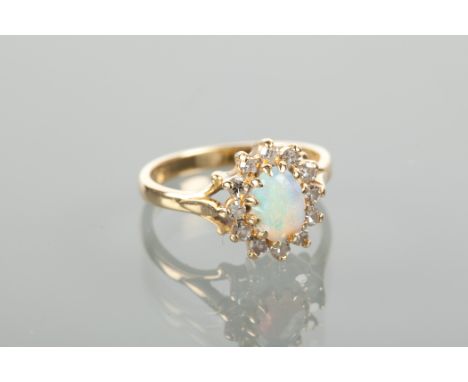 OPAL AND DIAMOND CLUSTER RING set with a central oval cabochon opal surrounded by brilliant cut diamonds, marked 18ct for eig