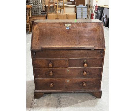 An 18th century oak writing bureau, the sloping fell enclosing a fitted interior with well, over two short and two long drawe