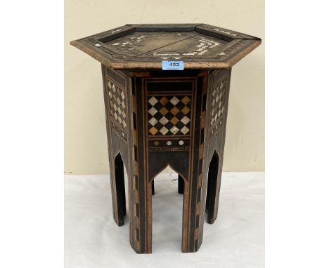 A 19th century Islamic octagonal table, parquetry inlaid with mother of pearl and various woods. 20' high. Extensive losses t