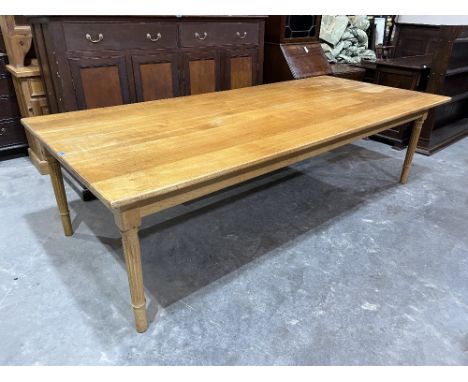 A light oak dining table on turned fluted legs. 108' long x 48' wide x 30' high