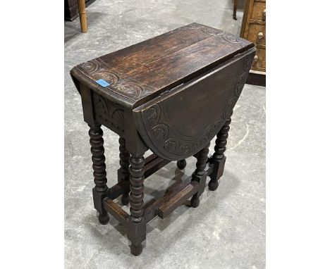 An oak dropleaf table with demi-lunette carved top on bobbin turned legs. 24' wide 