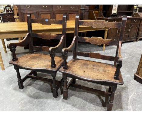 A pair of 19th century joined oak elbow chairs with ladder backs and moulded serpentine wide seats