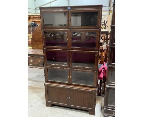 A mahogany bookcase, each of the four sections enclosed by a pair of glazed doors on a base enclosed by a pair of panel doors