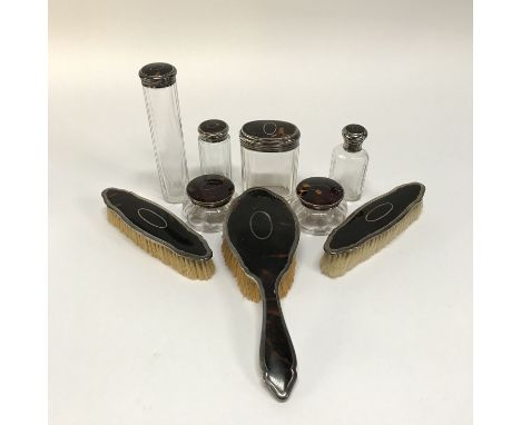 A nine piece tortoiseshell and silver dressing table set