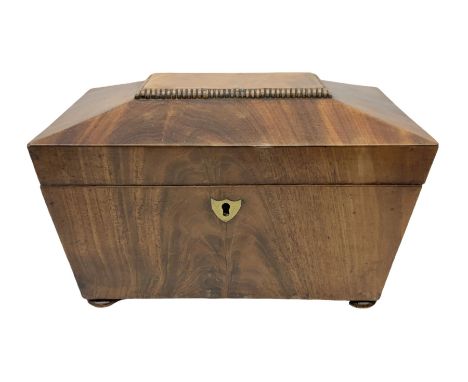 Mid 19th century mahogany tea caddy of sarcophagus form, the hinged lid opening to reveal twin lidded divided interior, raise