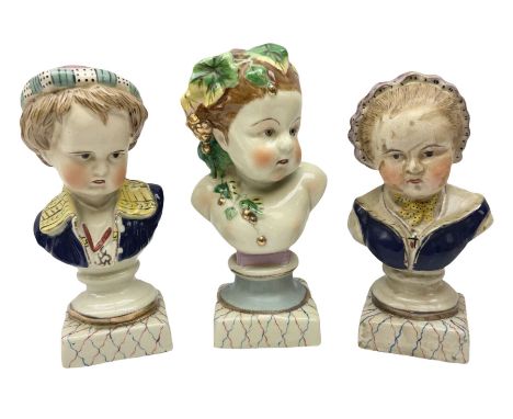19th century pair of hand painted ceramic busts of children, together with a third similar example of a putti with a crown of