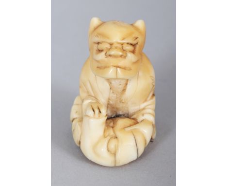 A JAPANESE MEIJI PERIOD IVORY NETSUKE OF A SEATED ONI NOH MASK MAKER, 1.4in high.