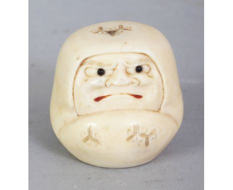 A SIGNED JAPANESE MEIJI PERIOD IVORY NETSUKE OF A DARUMA DOLL, with frowning expression, his mouth stained red, the base with