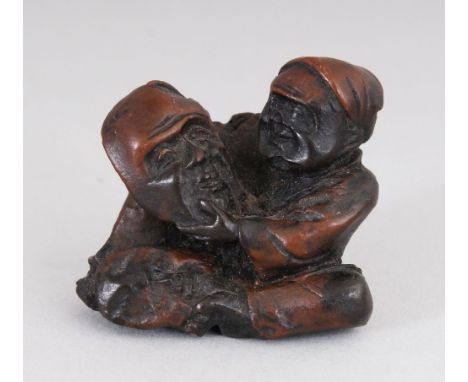 AN EARLY 20TH CENTURY JAPANESE CARVED WOOD NETSUKE OF A MASK MAKER, 1.25in high.